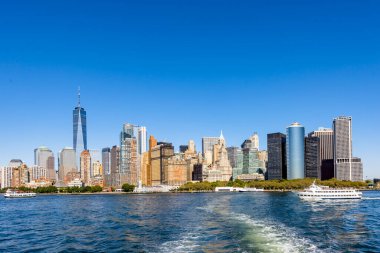 New York, ABD 'deki bir feribottan Manhattan şehri manzarası. Şehir merkezinde çok sayıda gökdelen, feribot, su.