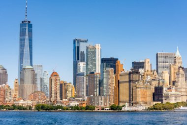 New York, ABD 'deki bir feribottan Manhattan şehri manzarası. Şehir merkezinde çok sayıda gökdelen, su.