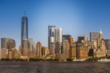 New York, ABD 'deki bir feribottan Manhattan şehri manzarası. Şehir merkezinde çok sayıda gökdelen, su.