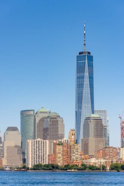 New York, ABD 'deki bir feribottan Manhattan şehri manzarası. Şehir merkezinde çok sayıda gökdelen, su.