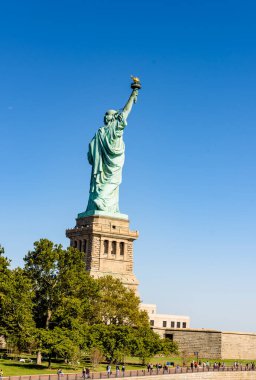 NEW YORK, ABD - EPTEMBER, 2019: Özgürlük Anıtı. Adada dolaşan çok sayıda turist, yeşillik