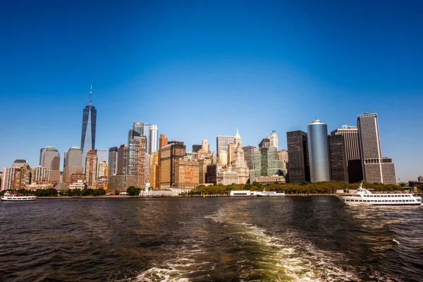 New York, ABD 'deki bir feribottan Manhattan şehri manzarası. Şehir merkezinde çok sayıda gökdelen, feribot, su.