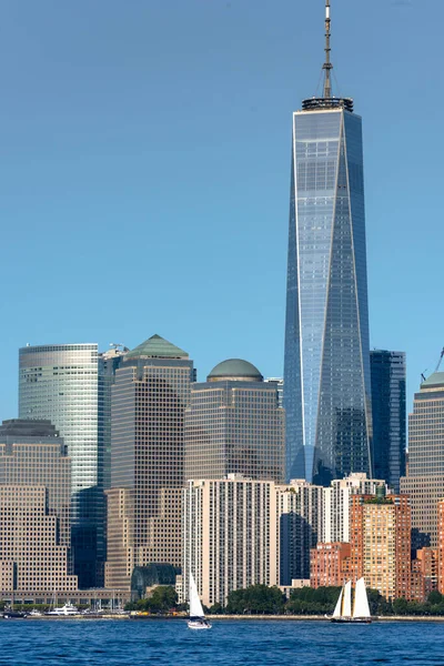 アメリカのリバティー島からニューヨークの街の風景 マンハッタン複数の高層ビルヨットが浮かぶ — ストック写真
