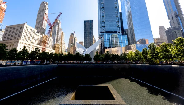 NEW YORK, ABD - Eylül 2019: Ulusal 11 Eylül Anıtı ve Müzesi, yeşillik ve insanlar, uzaktan gökdelenler