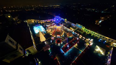 Romanya 'nın Sibiu kentindeki Büyük Meydan' ın gece görüş alanı geniş. Noel için dekore edilmiş eski şehir merkezi. Dönme dolap, buz pateni pisti, eski geleneksel binalar, insanlar