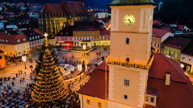 Romanya 'nın Brasov kentindeki Konsey Meydanı' nın hava aracı görüntüsü. Noel için dekore edilmiş eski şehir merkezi. İlçe Tarih Müzesi, binalar, insanlar