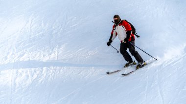 Romanya 'da kış aylarında Karpatlar' da kayak pistinde kayak yapan bir kayakçı. Kayak merkezi