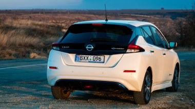 CHISINAU, MOLDOVA - 2022: Otoparktaki elektrikli Nissan Yaprağı, gün batımı