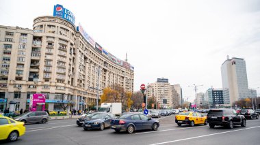BUCHAREST, ROMANIA - 2021 ARALIK: şehir merkezi caddesi. Birden fazla hareket eden araba ve binaları olan yol.,