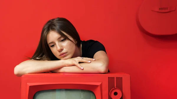 Молодая Женщина Позирует Студии Красными Стенами Мебелью Старый Винтажный Телевизор — стоковое фото