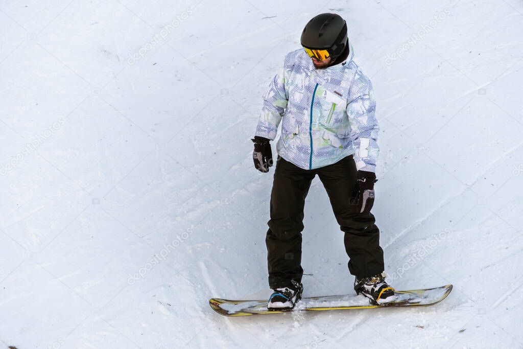Snowboarder riding on a ski track in the Carpathians in winter, Romania. Ski resort