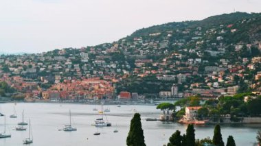 Saint-Jean-Cap-Ferrat 'taki Akdeniz sahili manzarası, yeşil tepeler, konut binaları, yatlar, Fransa
