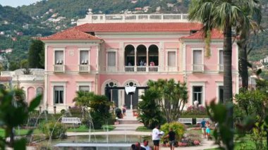 GÜZEL, FRANCE - 10 Eylül 2021 Yeşillik ve turistlerle dolu bahçeli Villa Eiffussi de Rothschild manzarası