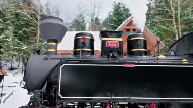 Kış, kar ve Romanya 'da bir tren istasyonundaki buharlı Mocanita treninin manzarası