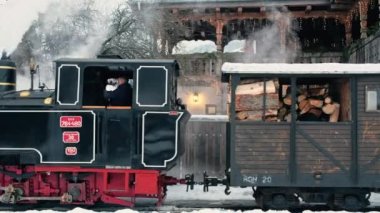 VISEU DE SUS, ROMANIA - HAZİRAN, 2022 Kışın bir tren istasyonunda hareket halindeki Mocanita buharlı treninin görüntüsü, kar, işçiler
