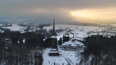 Romanya 'daki Peri-Sapanta Manastırı' nın kışın insansız hava aracı görüntüsü. Ana kilise ve bir bina, etrafında çıplak orman ve kar var.