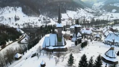 Romanya 'daki Barsana Manastırı' nın hava aracı görüntüsü. Ana kilise ve diğer binalar, çıplak orman ve karla kaplı tepeler, kış.
