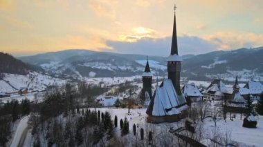 Romanya 'daki Barsana Manastırı' nın hava aracı görüntüsü. Ana kilise ve diğer binalar, ziyaretçiler, çıplak orman ve karla kaplı tepeler, kış