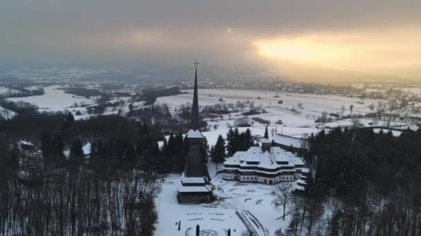 罗马尼亚Peri Sapanta修道院冬季的无人驾驶飞机图像 主教堂和一座建筑 光秃秃的森林和周围的雪 — 图库视频影像