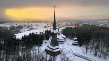 Romanya 'daki Peri-Sapanta Manastırı' nın kışın insansız hava aracı görüntüsü. Ana kilise ve bir bina, ziyaretçiler, çıplak orman ve kar.