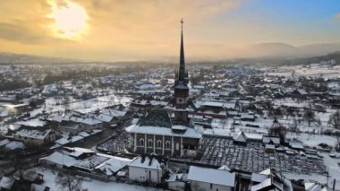 Romanya 'nın Sapanta kentindeki Merry Mezarlığı' nın insansız hava aracı görüntüsü. Birden fazla mezar taşı, kilise, kar.