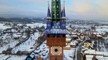 Romanya 'nın Sapanta kentindeki Merry Mezarlığı' nın insansız hava aracı görüntüsü. Birden fazla mezar taşı, kilise, kar.