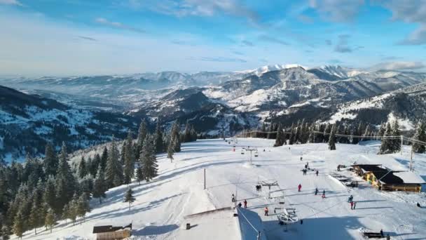 罗马尼亚喀尔巴阡山脉冬季滑雪场的空中无人驾驶图像 滑雪的人 光秃秃的森林 — 图库视频影像