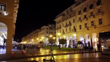 SALONIKI, GREECE - EYLÜL, 2020: Gece şehrin merkez meydanı birden fazla yürüyen insan ve bina ile