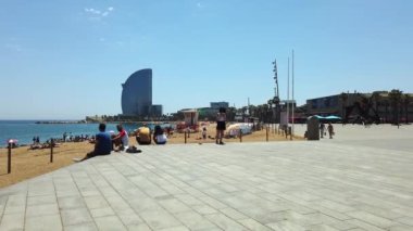 BARCELONA, İSPAN - 2021: dinlenen insanlarla sahil, toprak seti caddesi, yeşillik