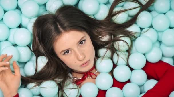 Mujer Joven Vestido Rojo Acostada Posando Montón Bolas Azules Plástico — Vídeos de Stock
