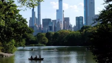 Brooklyn Köprüsü Parkı 'nın arka planında Manhattan Skyline olan yeşil çimlerinin görüntüsü. Gündüz vakti New York 'u yansıtan göl.