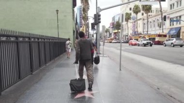 LOS ANGELES, ABD - Eylül 2019: Hollywood Şöhret Yolu 'nda yürüyen bir adamın sokak sahnesi