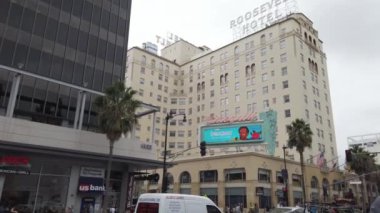 LOS ANGELES, ABD - Eylül 2019: şehir merkezinin sokak manzarası. Geleneksel tarzda binalar, arabalar, yürüyen insanlar, yeşillikler....