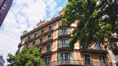 Barcelona, İspanya 'nın tramvayı. Güneşli bir günde klasik tarzda yapılmış eski bir bina, yeşillik.