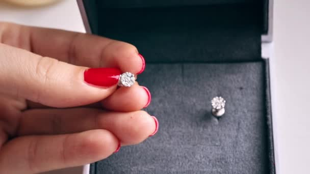 一个拿着钻石戒指的女人的近视一个装有另一个耳环的盒子 有红色钉子的手 — 图库视频影像