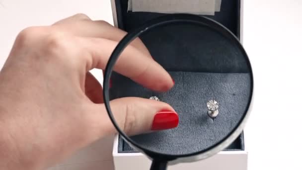 Nahaufnahme Einer Frau Die Ohrringe Mit Diamanten Durch Ein Vergrößerungsglas — Stockvideo