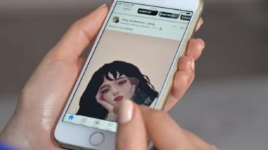CHISINAU, MOLDOVA - Şubat 2022: iPhone 'da Facebook kullanan bir kadının yakın görüntüsü. Kaydırılıyor