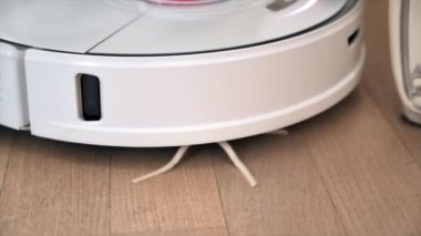 Evde robot elektrik süpürgesiyle çalışıyorum. Mobilyaların etrafında hareket ediyor. Yavaş çekim