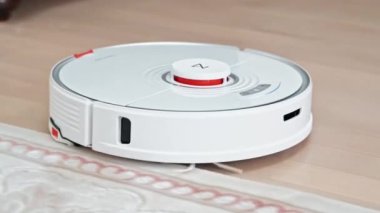 CHISINAU, MOLDOVA - Şubat 2022: Evde çalışan Roborock robotik elektrik süpürgesi. Bir halının kenarında yürüyorum.