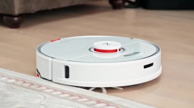 CHISINAU, MOLDOVA - Şubat 2022: Evde çalışan Roborock robotik elektrik süpürgesi. Bir halının kenarında yürüyorum.