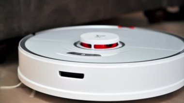 CHISINAU, MOLDOVA - Şubat 2022: Evde çalışan Roborock robotik elektrik süpürgesi. Mobilyaların etrafında hareket ediyor. Yavaş çekim