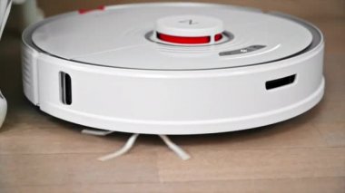 CHISINAU, MOLDOVA - Şubat 2022: Evde çalışan Roborock robotik elektrik süpürgesi. Mobilyaların etrafında hareket ediyor. Yavaş çekim