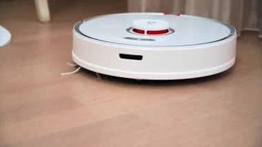 CHISINAU, MOLDOVA - Şubat 2022: Evde çalışan Roborock robotik elektrik süpürgesi. Mobilyaların etrafında hareket ediyor. Yavaş çekim