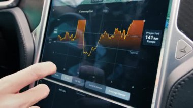 CHISINAU, MOLDOVA - 2022: Tesla Model S P90 iç mimarisi. Ekran, şarj ve tüketim bilgilerini kullanan sürücü