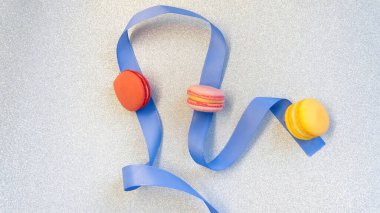 Çok renkli badem kurabiyesi bileşimi. Mavi bant ve parlak gümüş arkaplan