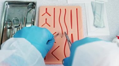 Cerrahlar özel silikon bloknotlara dikiş atmak için eğitim alırlar.