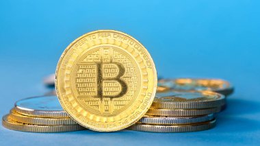 Fiziksel Bitcoin altın sikkeleri, mavi arkaplan