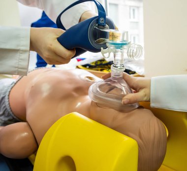 Tıp öğrencileri acil durumlar için tıbbi bir oyuncak bebek üzerinde acil kardiyopulmoner canlandırma uyguluyorlar.