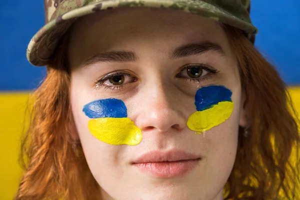 Плачущая Рыжая Женщина Военной Шляпе Национальных Флагах Украины Щеках Заднем — стоковое фото