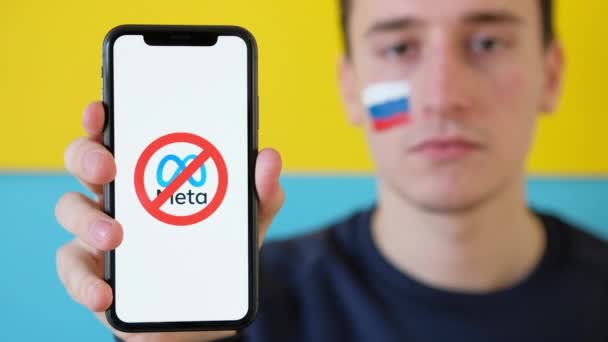 齐斯诺 Moldova 2022年3月 男人拿着一个带有梅塔标志的电话 俄罗斯国旗在他的脸颊上 乌克兰为背景 — 图库视频影像